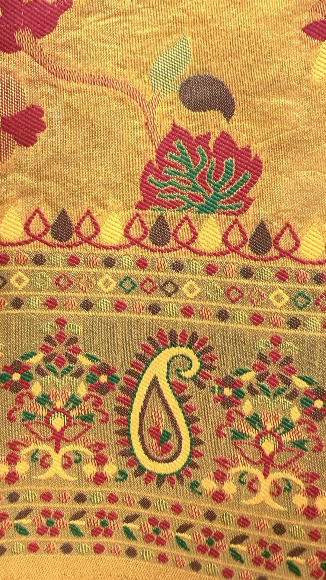 Decorative fabric with intricate patterns and colors on a gold background